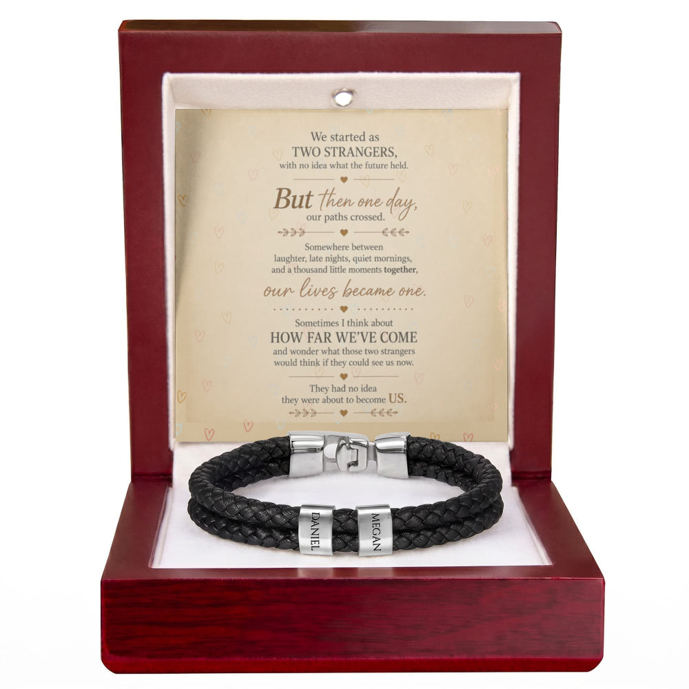 A black braided leather bracelet with silver-toned metal bands engraved with 'HONOR' and 'LOVE', presented inside an open reddish-brown wooden gift box with a white insert and a sentimental quote card.
