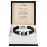 A black braided leather bracelet with silver metal accents engraved with 'LOVE' and 'FOREVER', presented in an open white gift box with a black outer lid. The inside lid features a printed sentimental message card.
