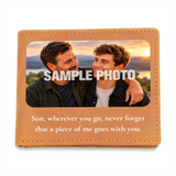 A tan leather wallet or photo plaque shown closed on a white background. The front has a large printed photo area with a sample photo of two men and the words “SAMPLE PHOTO” across the center, plus a printed message below: “Son, wherever you go, never forget that a piece of me goes with you.