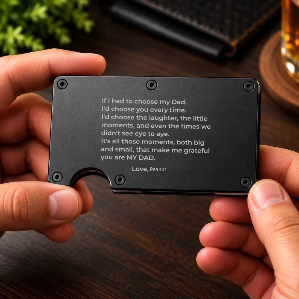 A person holds a slim black metal card holder with engraved text reading 'If I had to choose my Dad, I'd choose you every time.