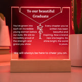 Decorative plaque with engraved message and necklace design on a wooden base.