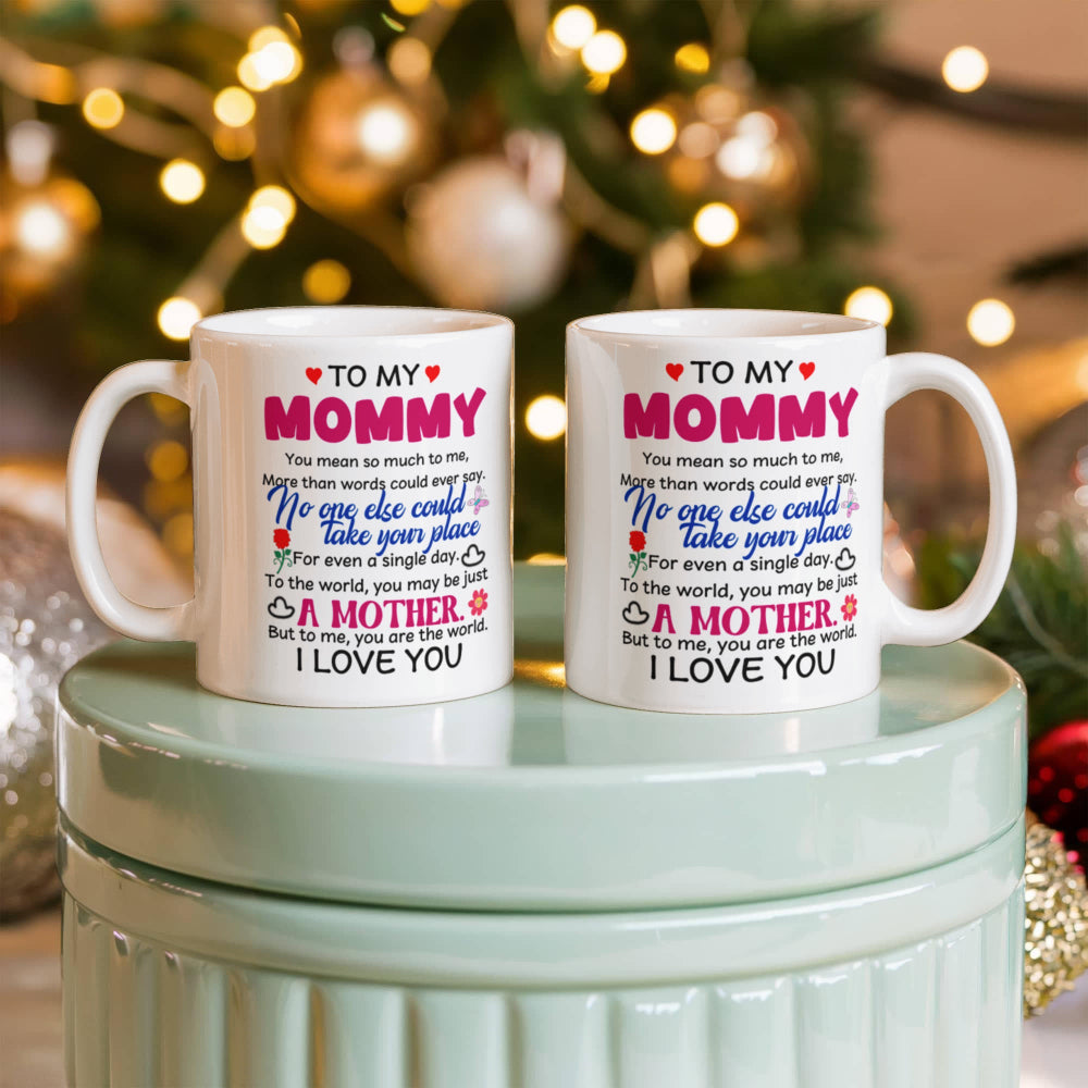 Two 11oz mugs with personalized messages for a mommy in front of a decorated Christmas tree.