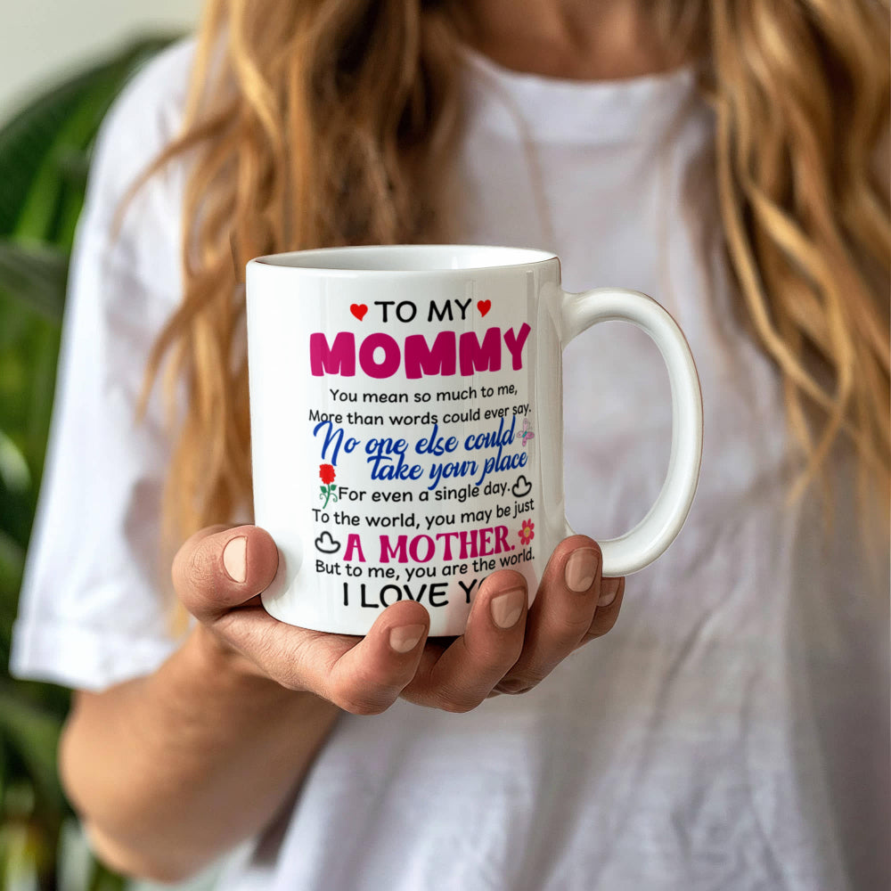 Person holding a 11oz mug with a heartfelt message to 'Mommy' against a blurred background