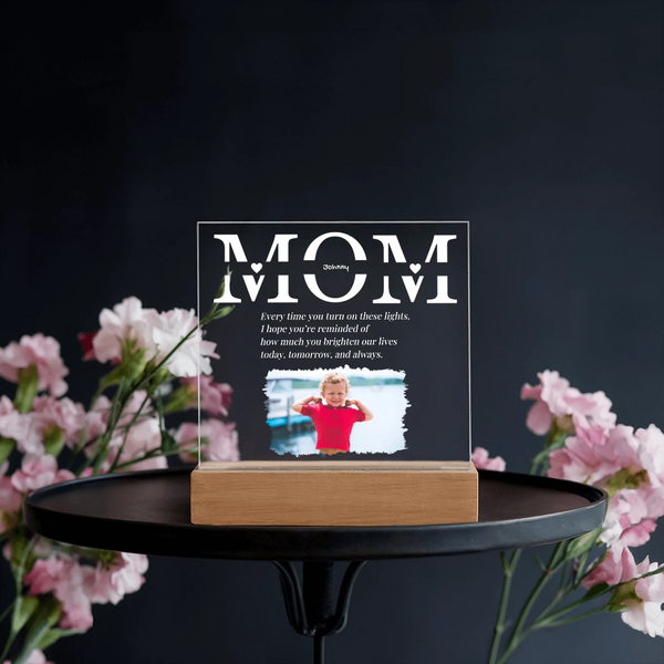 Acrylic plaque with 'MOM' text and photo of a child on a stand with flowers in the background
