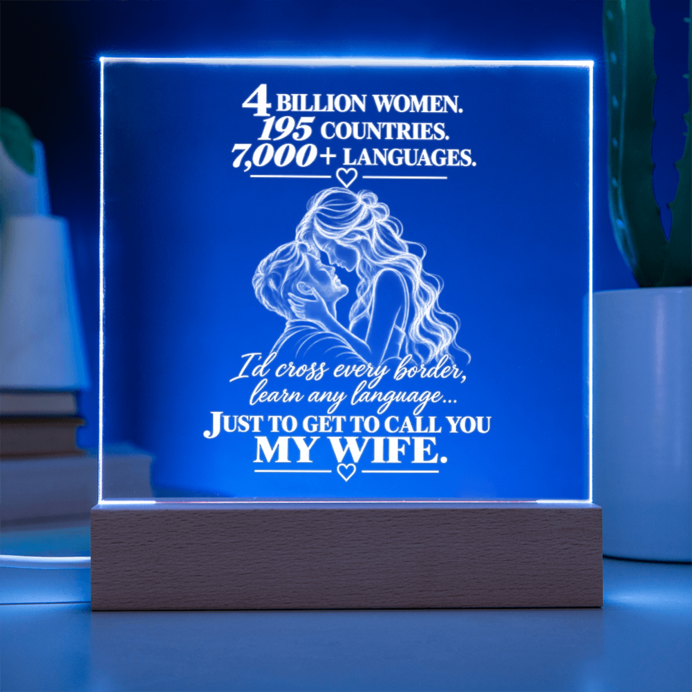 A rectangular LED acrylic lamp on a wooden base, glowing blue with white text that reads, '4 BILLION WOMEN. 195 COUNTRIES.