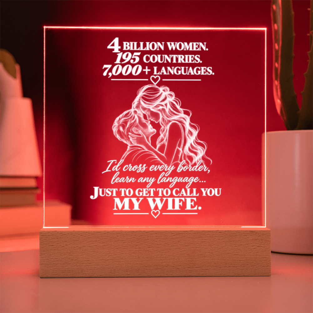 A square acrylic LED lamp on a wooden base, glowing with a warm red light. The front of the clear panel has white laser-engraved text celebrating women and a couple illustration, with the phrase 'Just to get to call you my wife.