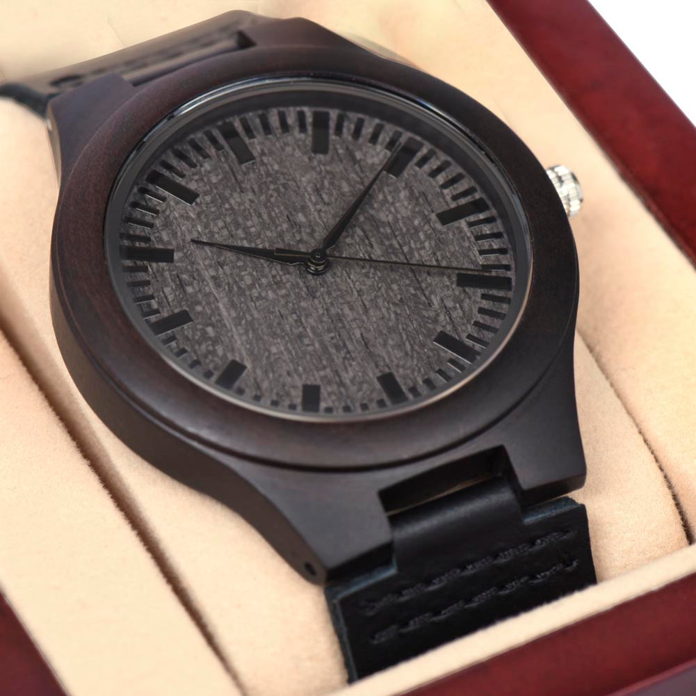 Black wristwatch with textured face in a wooden box